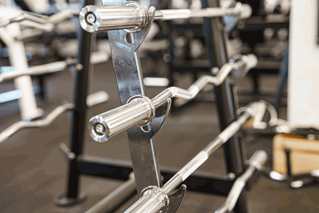 Rack avec plusieurs barres de musculation de différents poids et formats